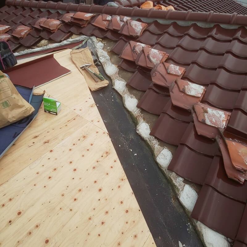 既存瓦を部分撤去して新しい屋根下地を施工している写真